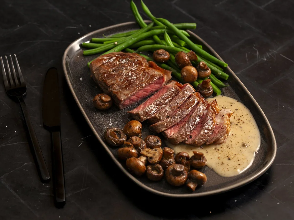 Steak with green beans on the plate.