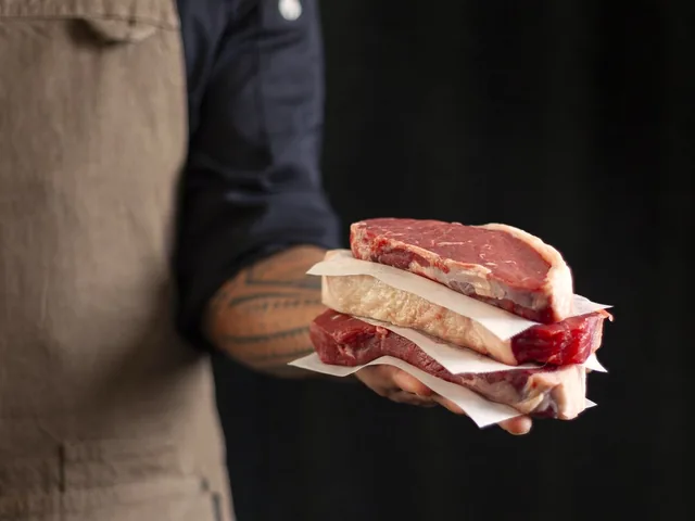 Steaks in butcher’s paper, held out across the counter